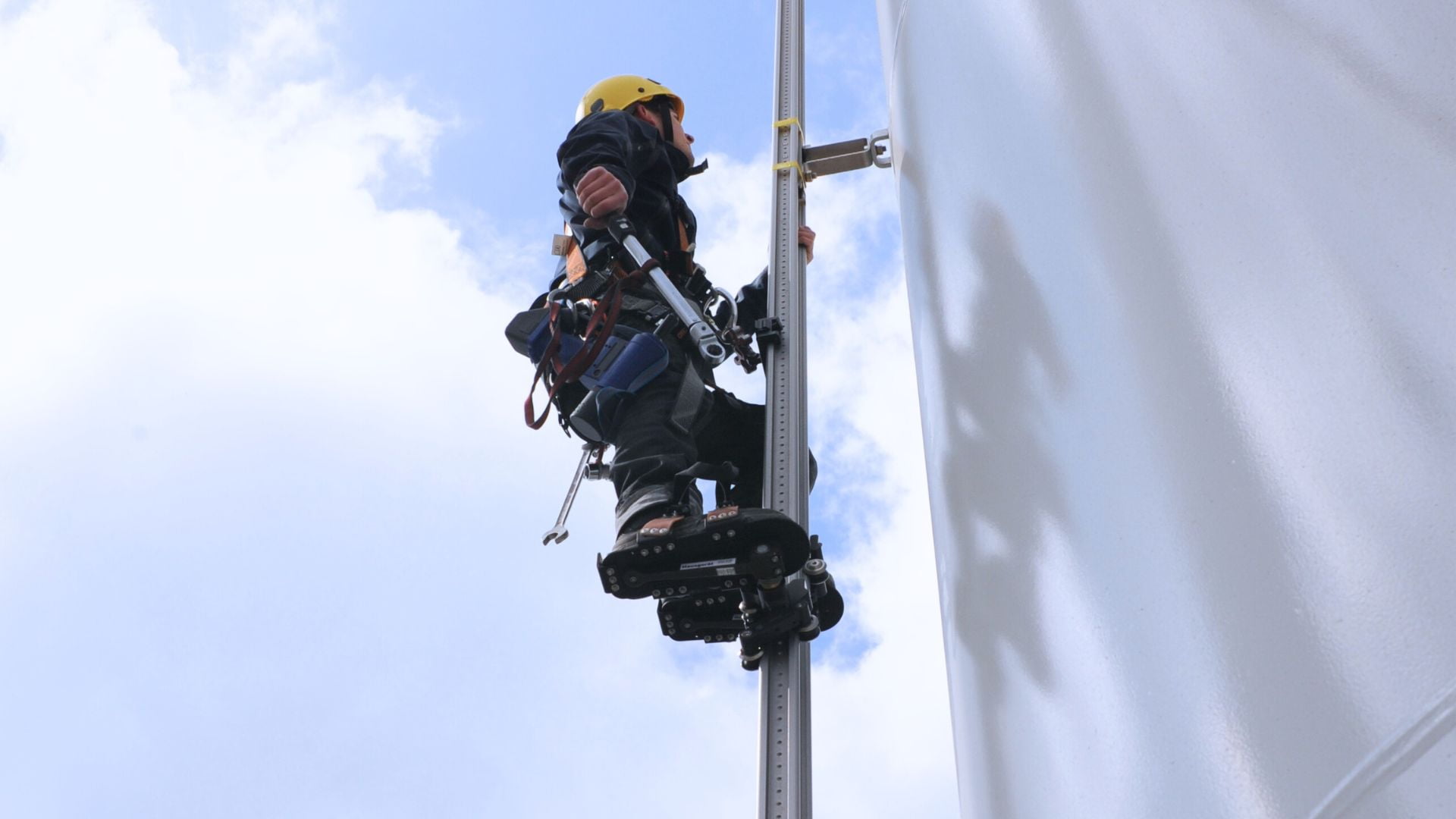 Retrofit: Von der Steigleiter zum schienengeführten System - Techniker steigt mit moderner Absturzsicherung von HighStep